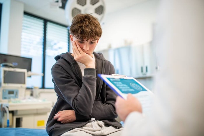A mental health professional talking with a patient during a supportive psychiatric consultation about gender identity concerns.