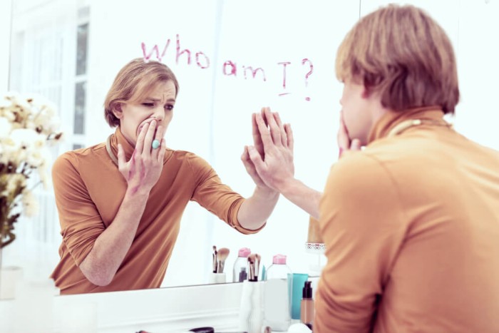 An individual appearing deep in thought, symbolizing confusion and self-reflection about their gender identity.