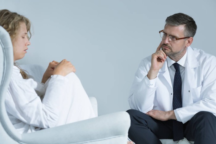 Doctor providing personalized care to a patient at a bipolar disorder treatment center, discussing treatment options and therapy plans