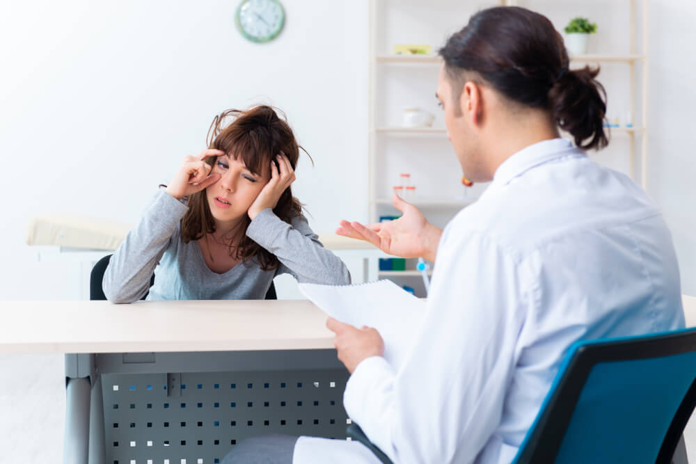 patient discussing with psychiatrist about insomnia, with tired expression, showing effects of chronic insomnia